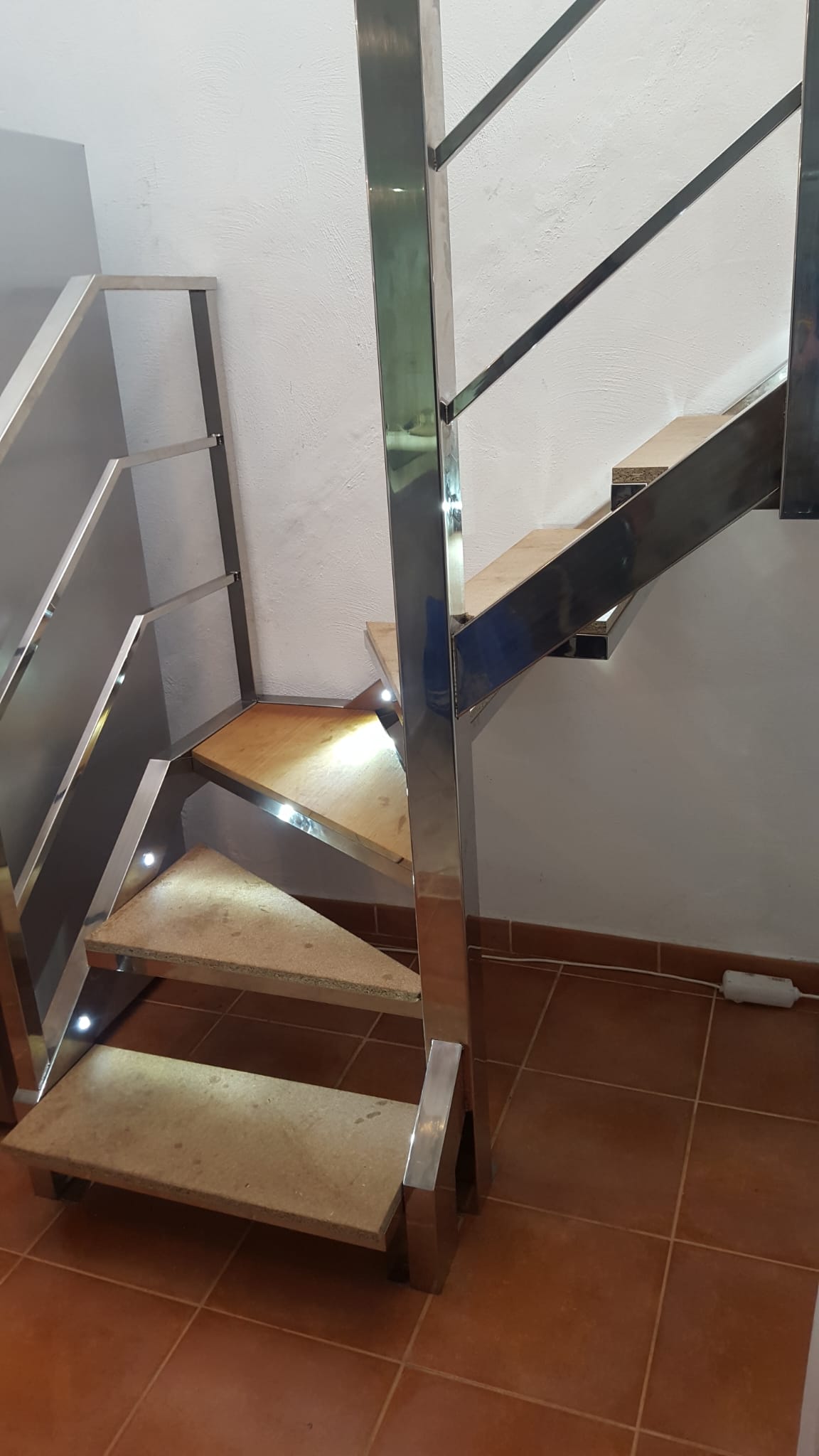 Escalera con perfil LED perimetral y puntos de luz empotrados en el techo