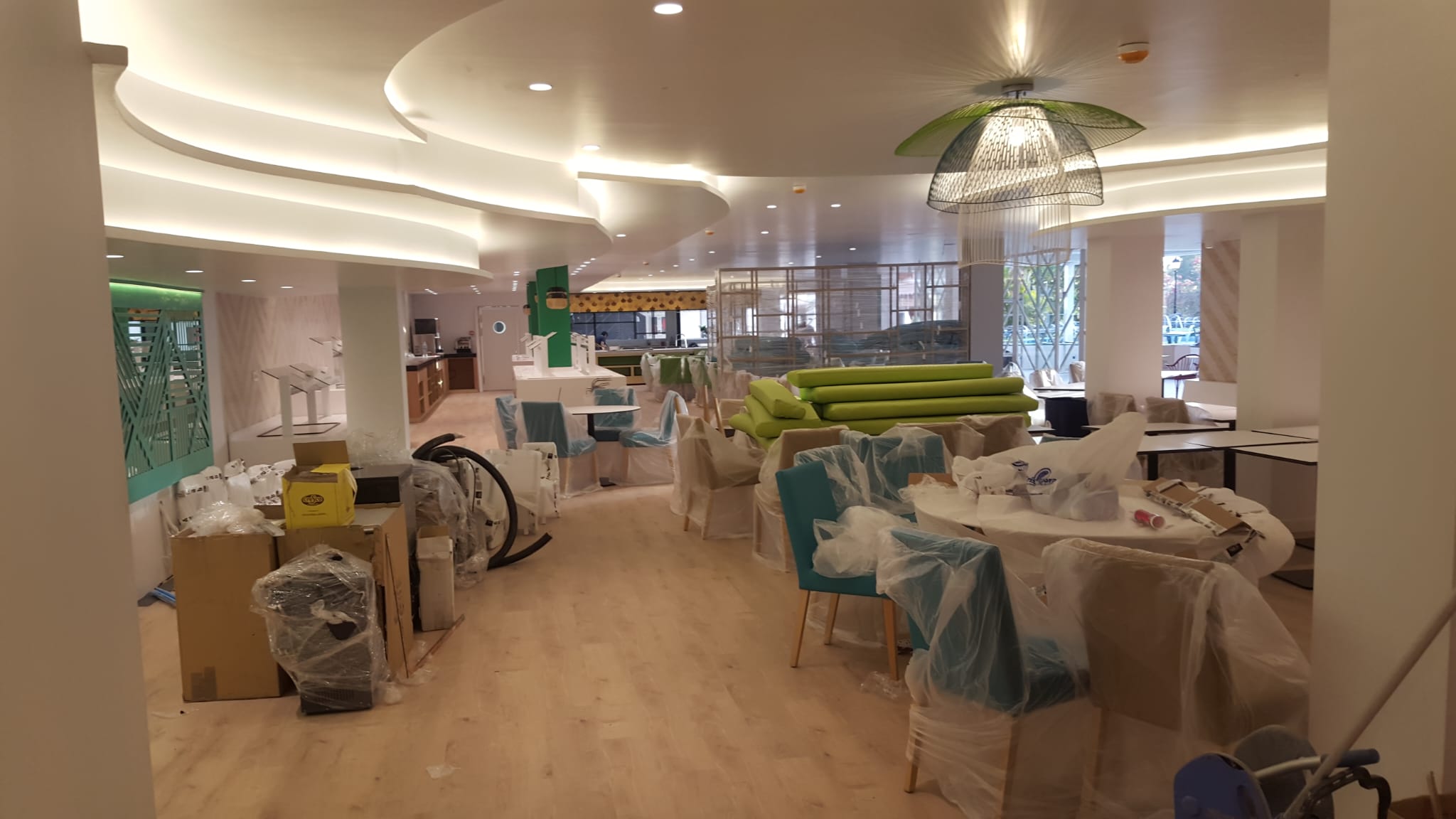 Comedor de hotel con iluminación de techo integrada y lámpara decorativa