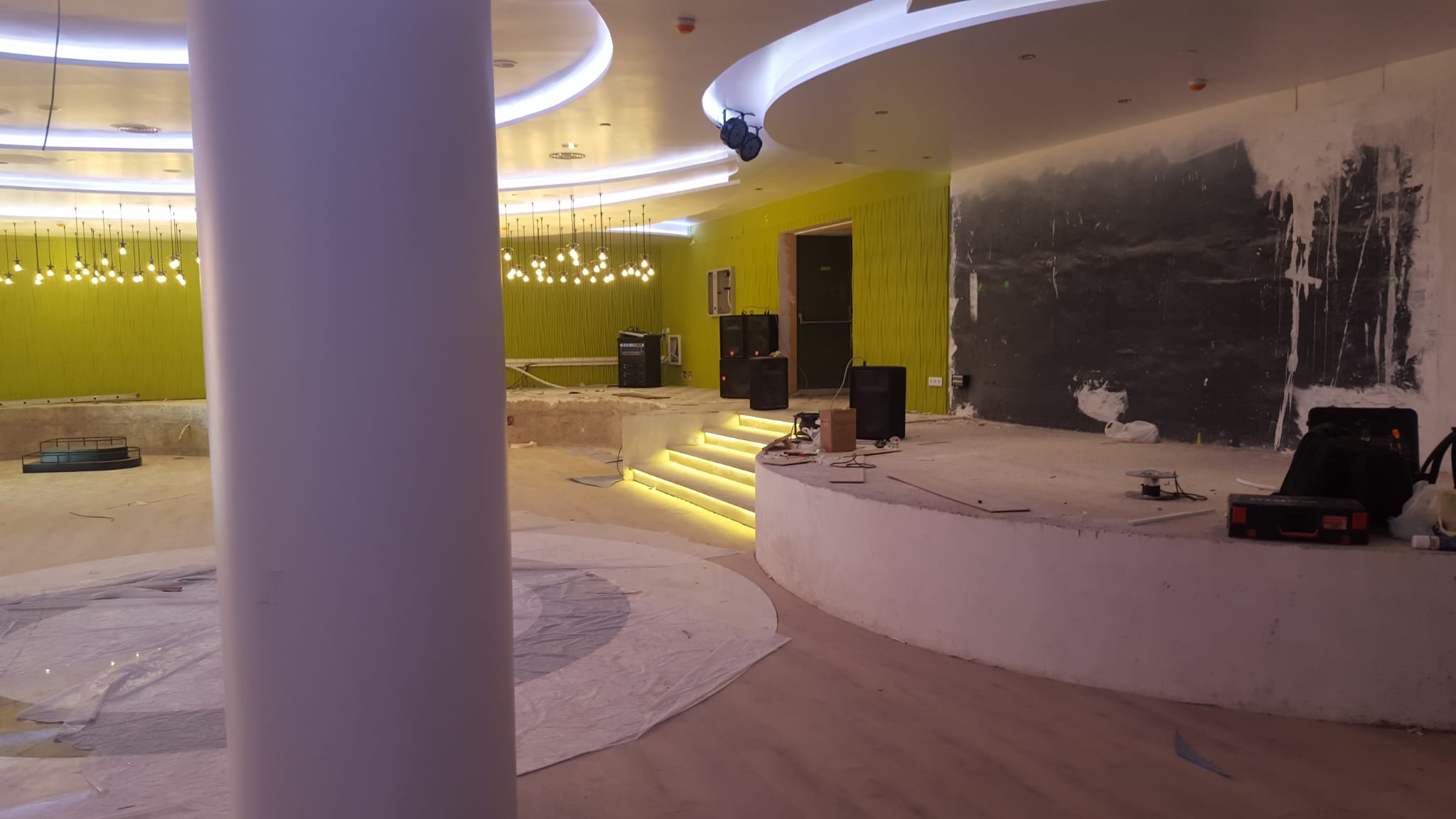 Sala de eventos con escalera y perfil LED de color junto al escenario