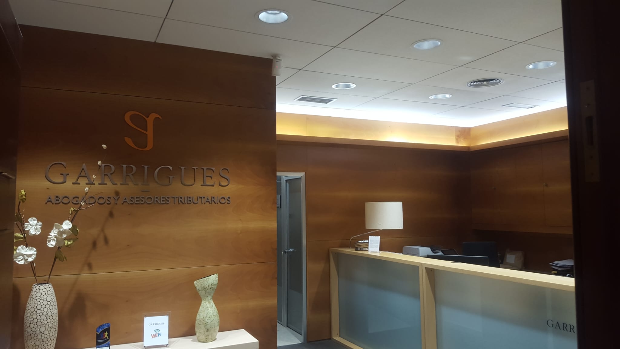 Recepción de oficinas con iluminación de techo empotrada y perimetral