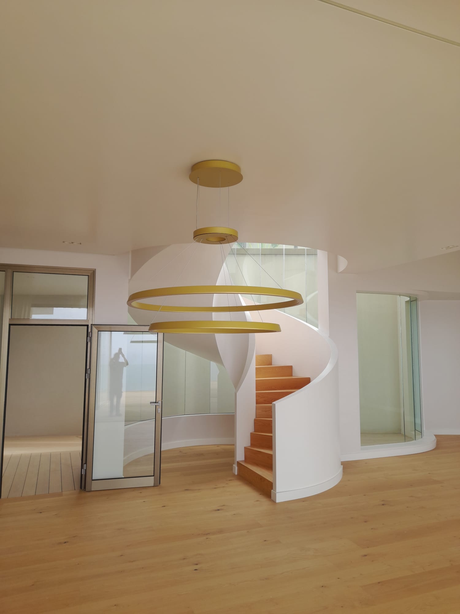 Escalera curva con lámpara de diseño y puntos de luz empotrados